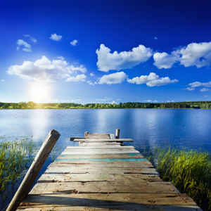 ypsi.consulting: Our experince for Your success wooden pier leading into calm blue lake under a sunny summer sky